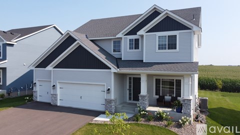 A two-story house with a garage is available for sale.