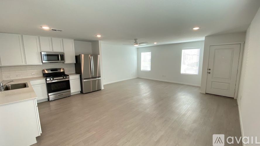 A kitchen with white cabinets and a wooden floor.