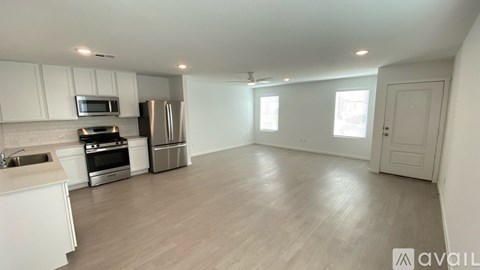A kitchen with white cabinets and a wooden floor.