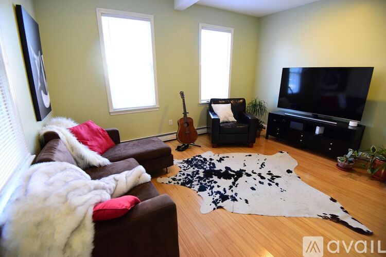 A living room with a cowhide rug on the floor.