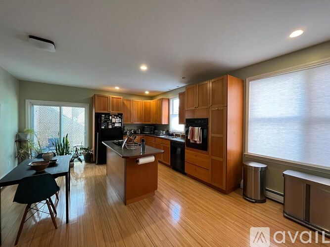 A kitchen with wooden cabinets and a black table.