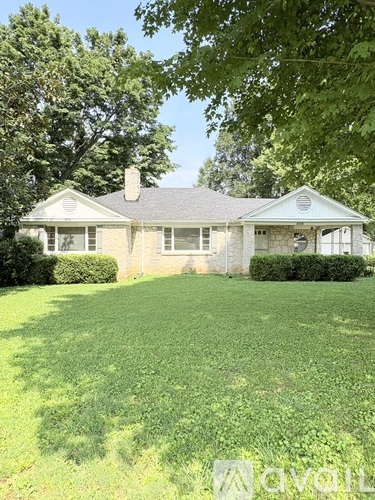 A house with a well-manicured lawn in front.