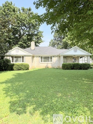 A house with a well-manicured lawn in front.