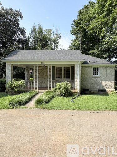 A small house with a porch and a sign that says "AVAIL".