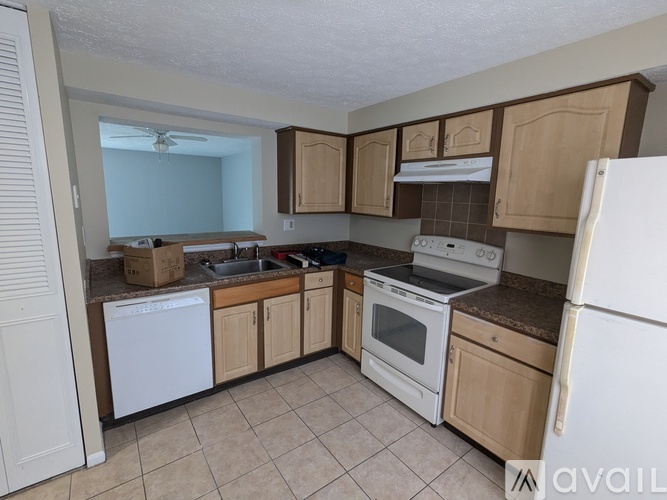 A kitchen with white appliances and wooden cabinets.