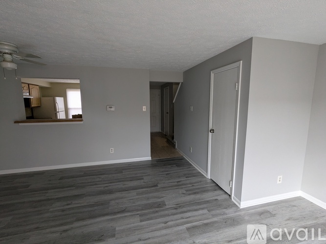 A room with a grey floor and white walls is available for rent.