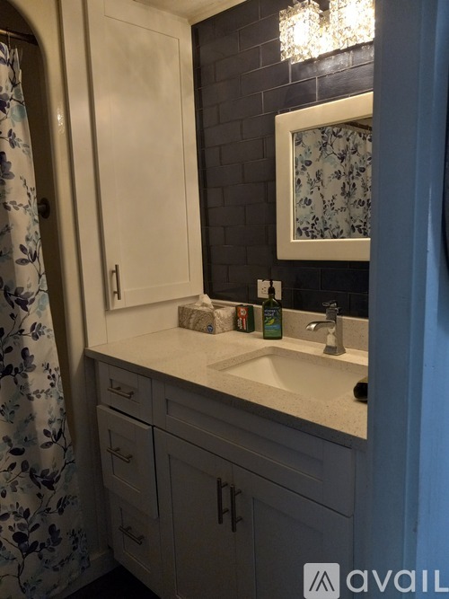 A bathroom with a sink, mirror, and cabinets.