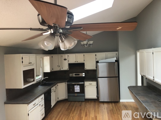 A kitchen with a fan hanging from the ceiling.