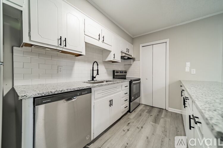 A kitchen with white cabinets and appliances.