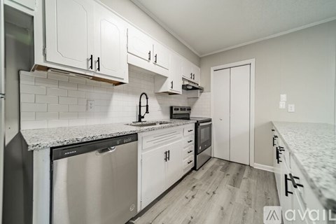 A kitchen with white cabinets and appliances.