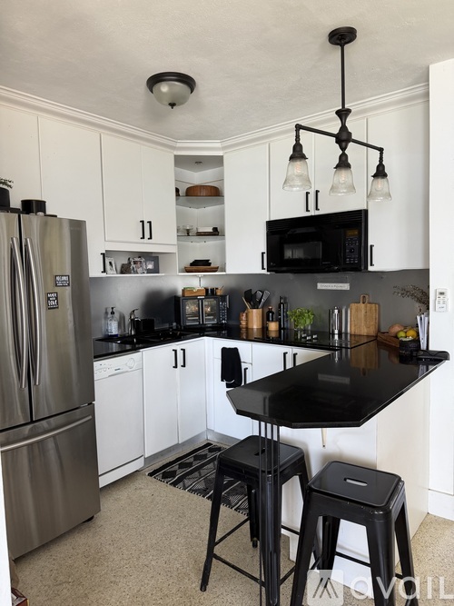 A kitchen with black countertops and white cabinets.