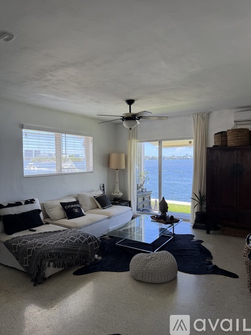 A living room with a large bed and a view of the water.