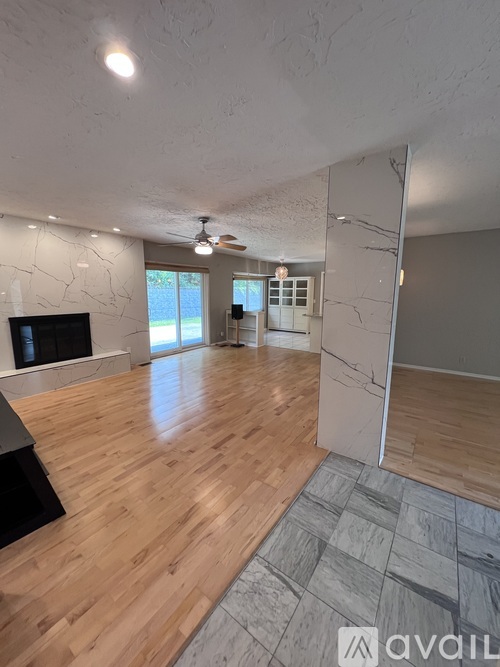 A spacious room with wooden flooring and a television.