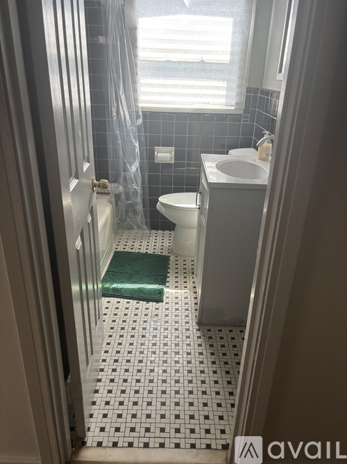 A bathroom with a toilet, sink, and shower.