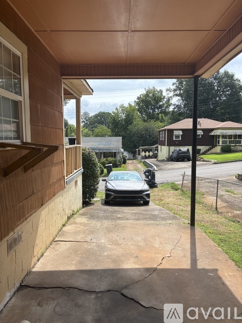 A black car is parked on a driveway.