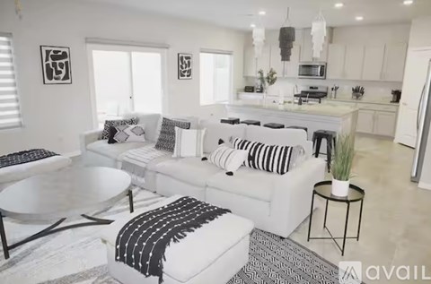 A modern living room with a white couch and a black and white rug.