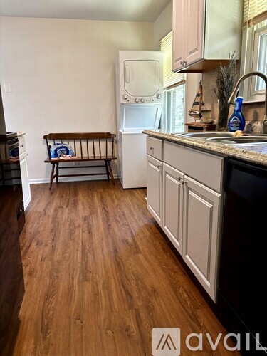 A kitchen with wooden floors and a white fridge.