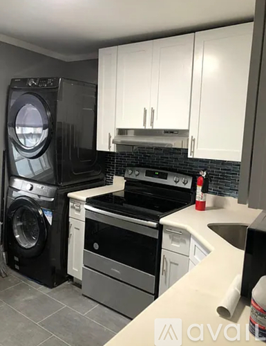 A kitchen with a black oven and white cabinets.
