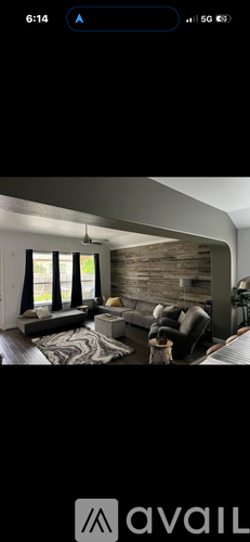A modern living room with a large window and a stone wall.
