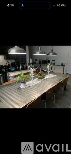 A kitchen with a table and chairs in the foreground and a plant on the table.