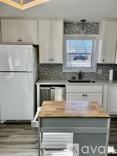 A kitchen with a white refrigerator and wooden countertop.