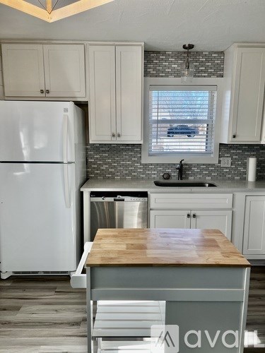 A kitchen with a white refrigerator and wooden countertop.