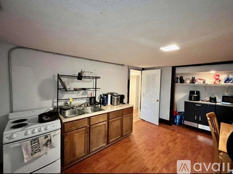 A kitchen with a white stove and wooden cabinets.