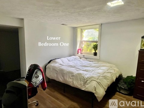 A bedroom with a bed, a window, and a sign that says "Lower Bedroom One".