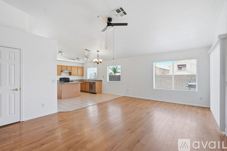 A spacious living room with hardwood floors and a ceiling fan.