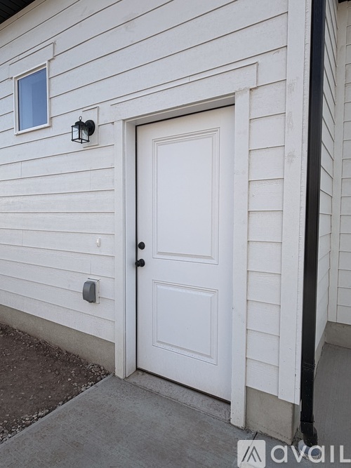 A white door with a black handle and a small window above it.