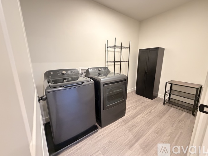 A kitchen area with two ovens and a black cabinet.