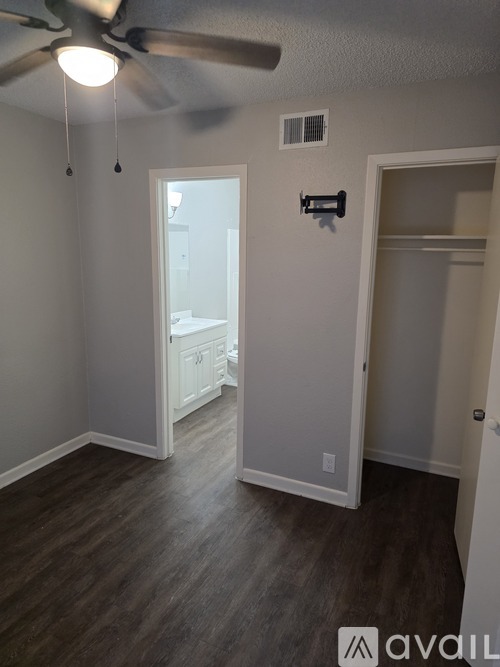 A room with a ceiling fan and a door leading to another room.