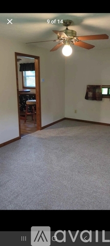 A room with a ceiling fan and a light on.