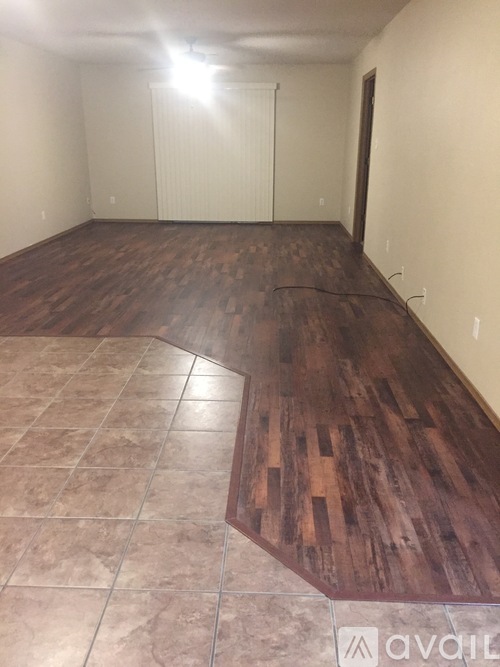 A room with a wooden floor and a tiled floor.