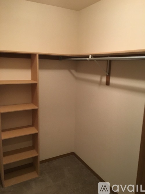 A wooden shelf with four shelves is mounted on a wall.