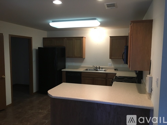 A kitchen with a white counter top and wooden cabinets.