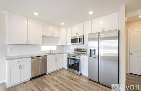 A kitchen with white cabinets and stainless steel appliances.