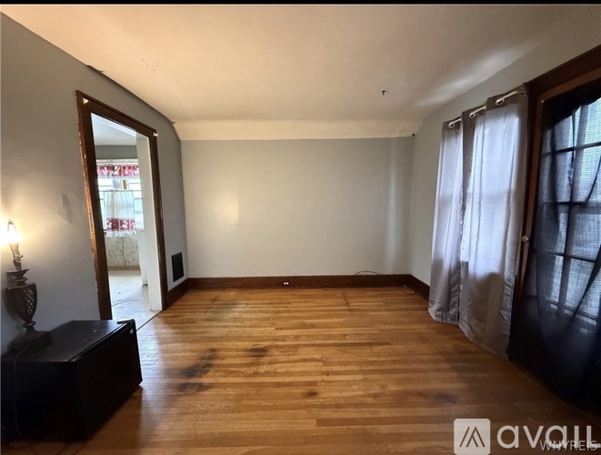 A room with wooden floors and a large mirror on the wall.