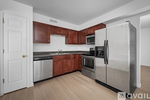 A kitchen with a white door and a stainless steel refrigerator.
