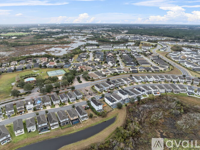 A bird's eye view of a residential area with houses and a swimming pool.