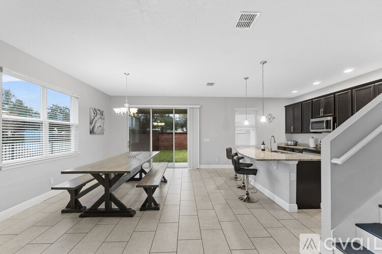 A kitchen with a dining table and chairs is shown.