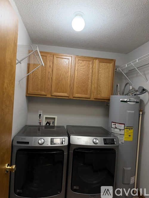 A small kitchen with two ovens and a refrigerator.