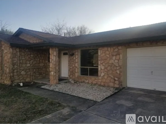 A house with a stone wall and a garage door.