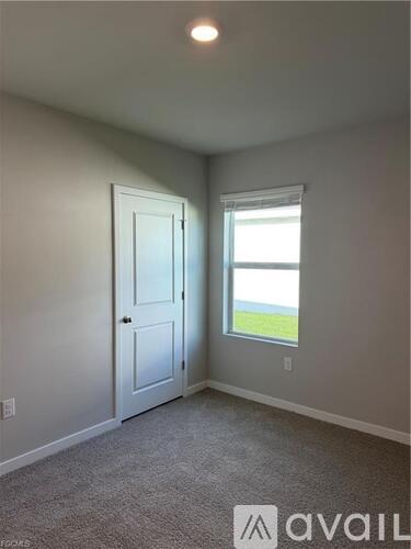 A room with a door and a window showing a view of the outside.