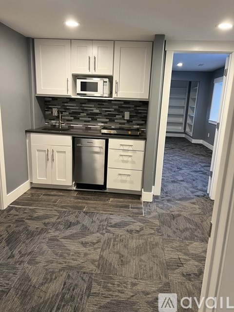 A kitchen with a black granite countertop and white cabinets.