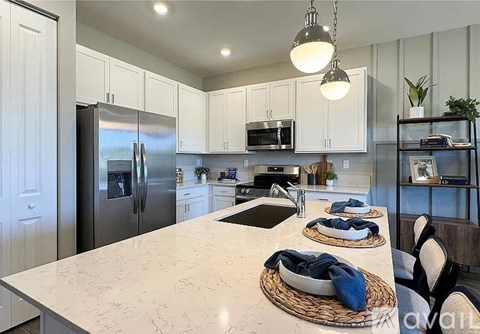 A kitchen with a marble countertop and stainless steel appliances.