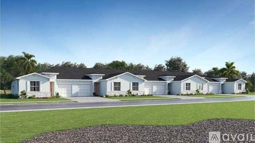 A row of houses with a grassy front yard and a gravel area in front.