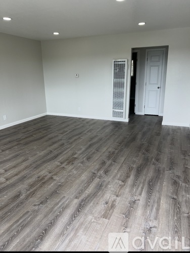 A room with wooden flooring and a white door.