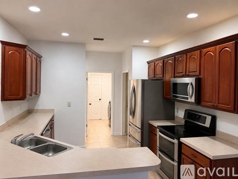 A kitchen with wooden cabinets and stainless steel appliances.