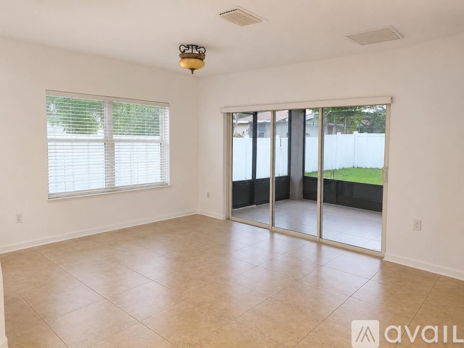 A room with a sliding glass door leading to a backyard.